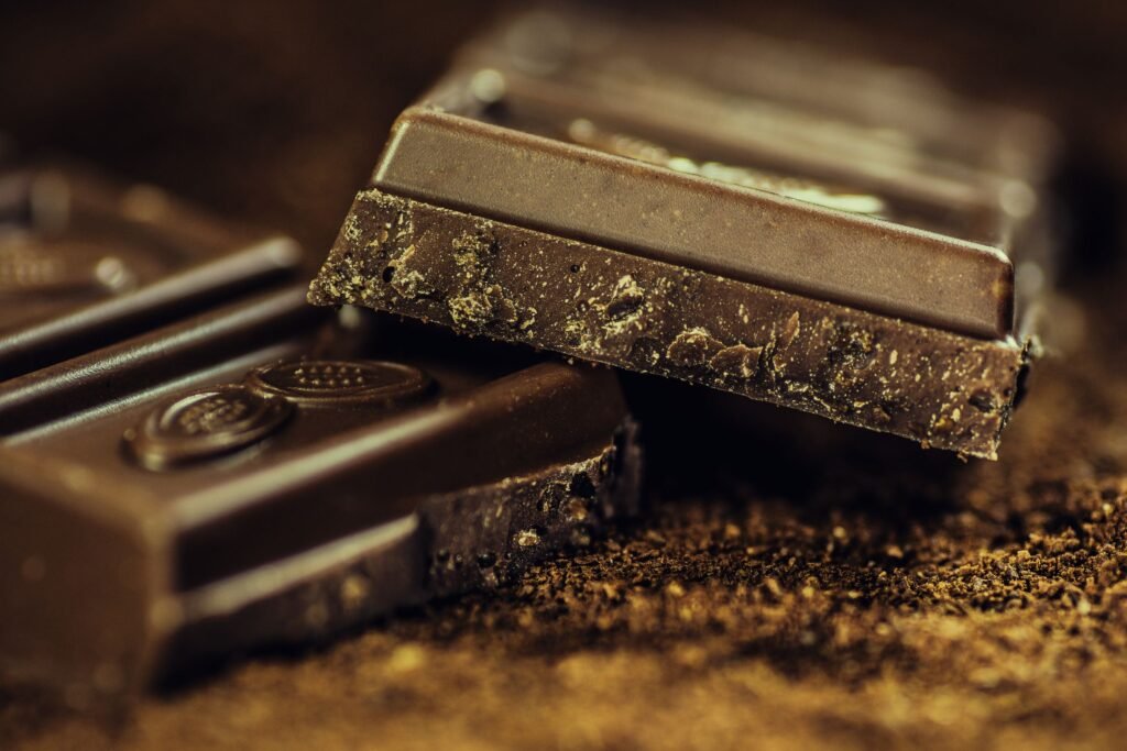 Close-up of dark chocolate squares dusted with cocoa, one of the higher-risk types behind chocolate poisoning in dogs